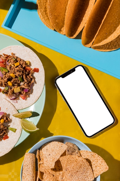 Free photo flat lay mexican food and smartphone