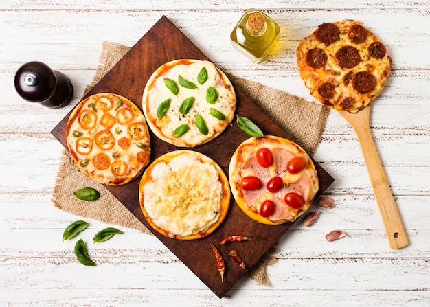 Flat lay of mini pizza on wood tray