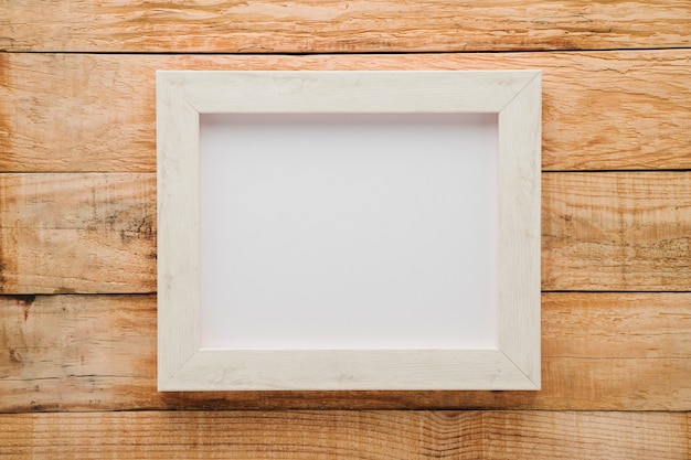 Flat lay minimalist white frame with wooden background