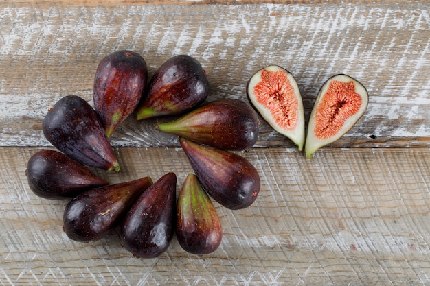 Free photo flat lay mission figs with fig halves on wooden table. horizontal