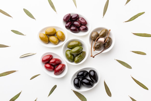 Flat lay mix of black red green purple yellow olives and oil