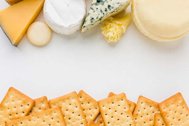 Flat lay mix of gourmet cheese with crackers