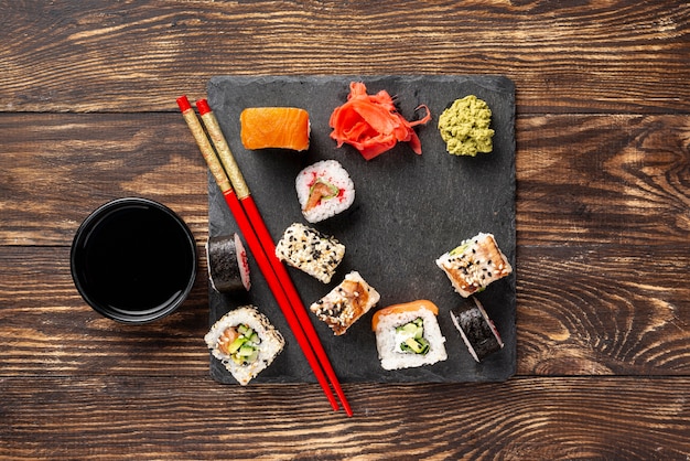 Flat lay mix of maki sushi rolls with chopsticks