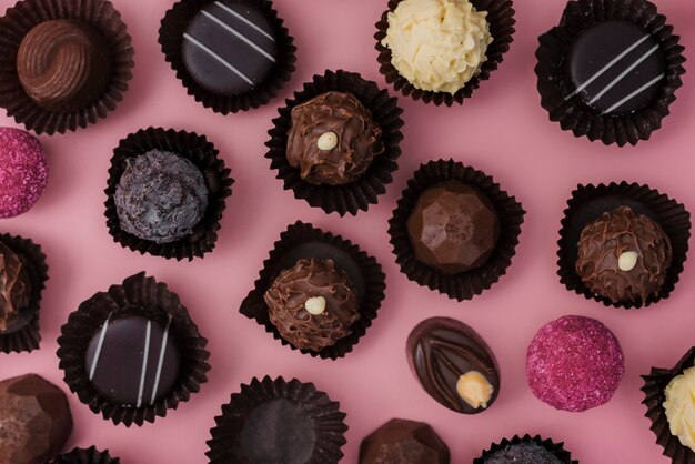 ピンクの背景にチョコレートのフラットレイアウトミックス 無料の写真