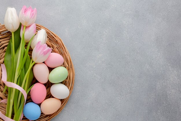 Flat lay of multicolored tulips with easter eggs and copy space