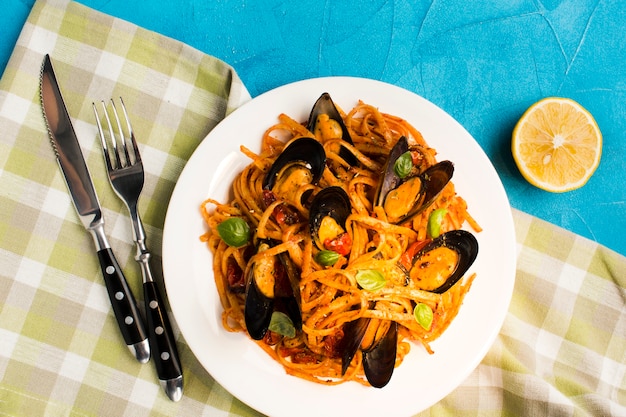 Flat-lay mussel pasta on tablecloth