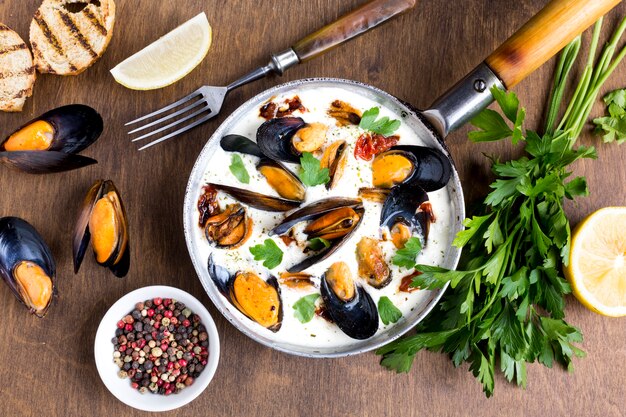 Flat-lay mussels in white sauce and spices