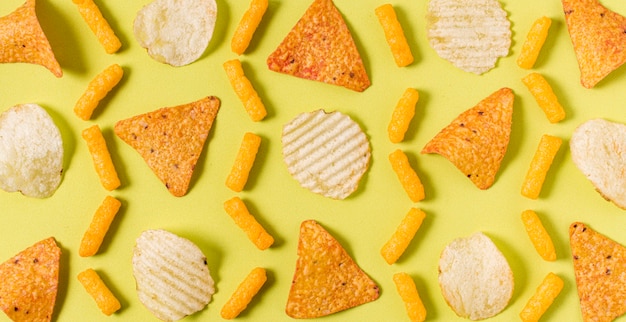 Flat lay of nacho chips with potato chips and cheesy puffs