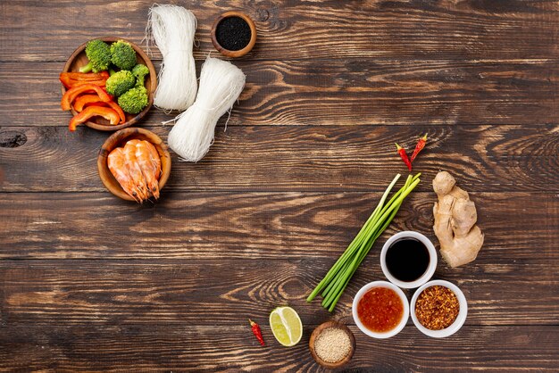 Flat lay noodles spices and chopsticks on wooden backgrouns
