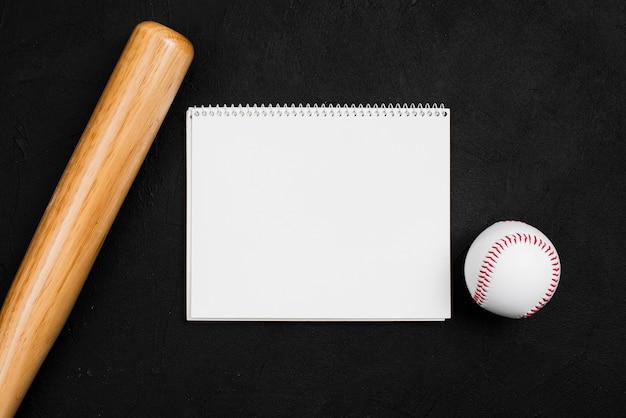 Flat lay of notebook with baseball and bat