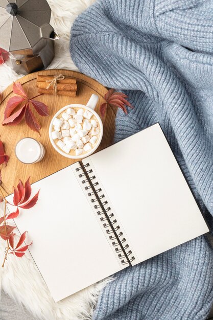 Flat lay of notebook with cup of hot cocoa with marshmallows