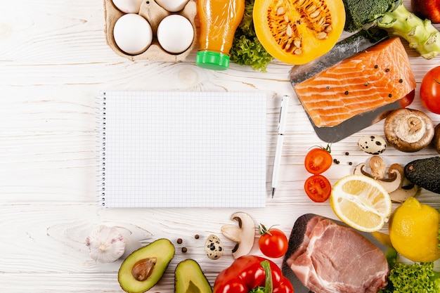 Flat lay of notebook with ingredients and salmon