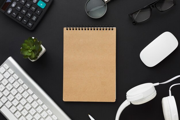 Flat lay of notebook with keyboard on desktop