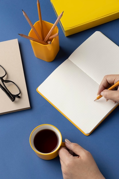 Flat lay notebook with to do list on desk with cup of coffee beside