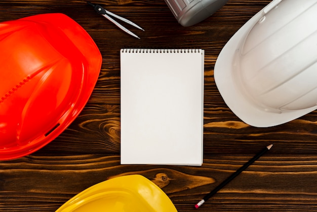 Flat-lay notepad with construction helmets