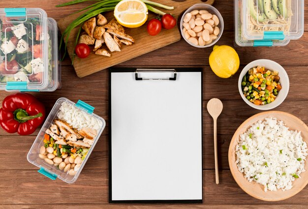 Flat lay of notepad with different food and casseroles