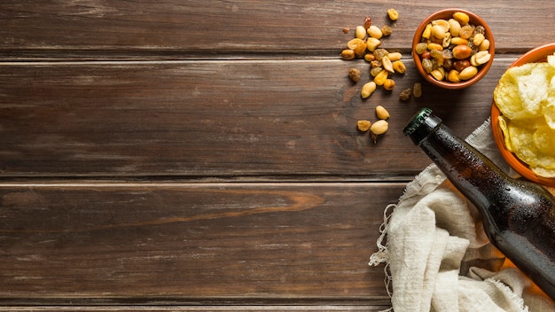 Flat lay of nuts with beer bottles and chips