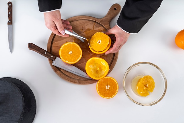 Бесплатное фото Плоская планировка повара, нарезающего апельсин