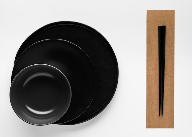 Бесплатное фото Плоская планировка палочек для еды с посудой