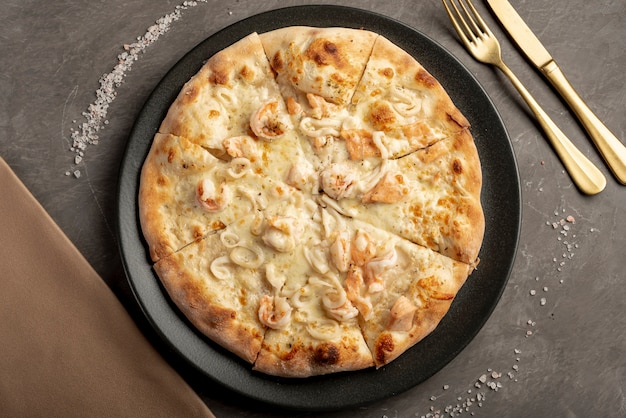 Бесплатное фото Плоская раскладка вкусной пиццы на столе