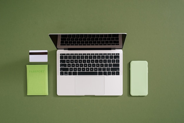 Плоская планировка ноутбука, кредитной карты, мобильного телефона и паспорта на зеленом