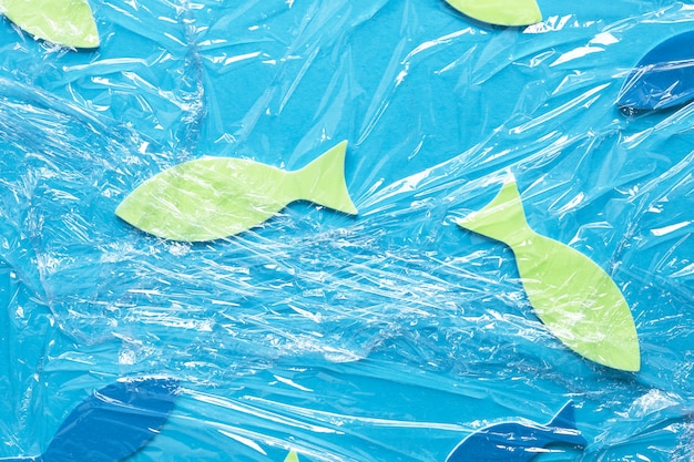 Бесплатное фото Плоская укладка бумажной рыбы под полиэтиленовую пленку