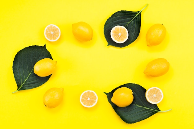 Бесплатное фото Плоская планировка спелых лимонов с листьями