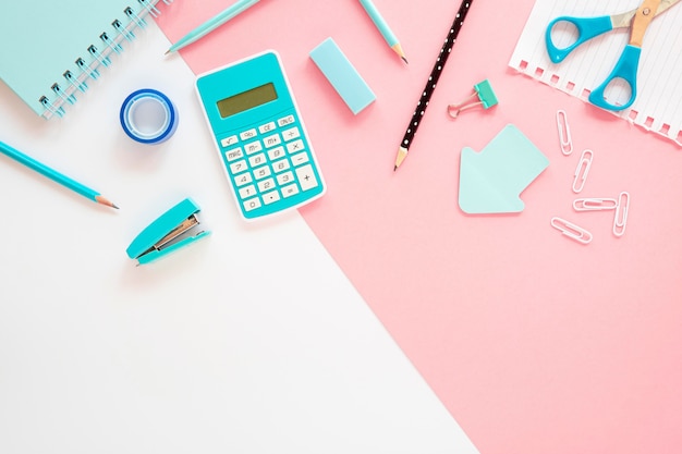 Flat lay of office stationery with calculator and stapler