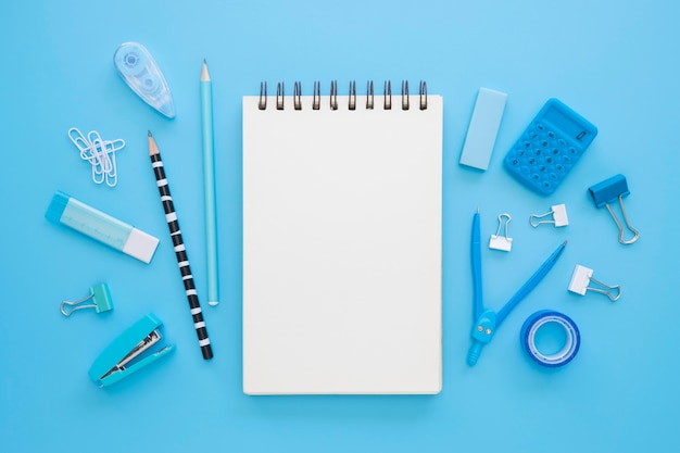 Flat lay of office stationery with notebook and compass