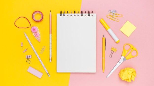 Flat lay of office stationery with notebook and elastic bands