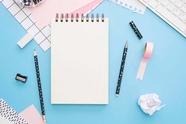 Flat lay of office stationery with notebook and tape