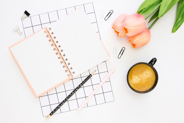 Free photo flat lay of office stationery with tulips and coffee