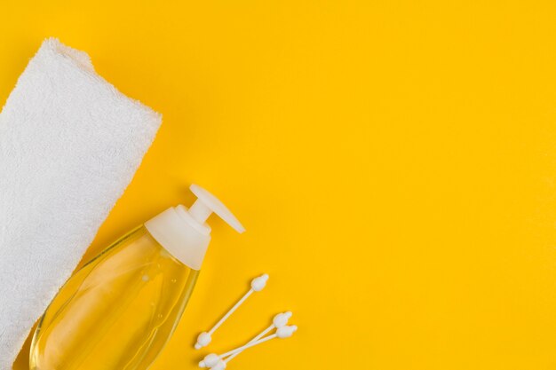 Flat lay of oil dispenser and towel for baby shower with copy space