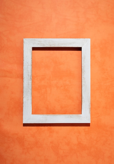 Flat lay old white frame on orange background