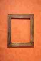 Free photo flat lay old wooden frame on orange background