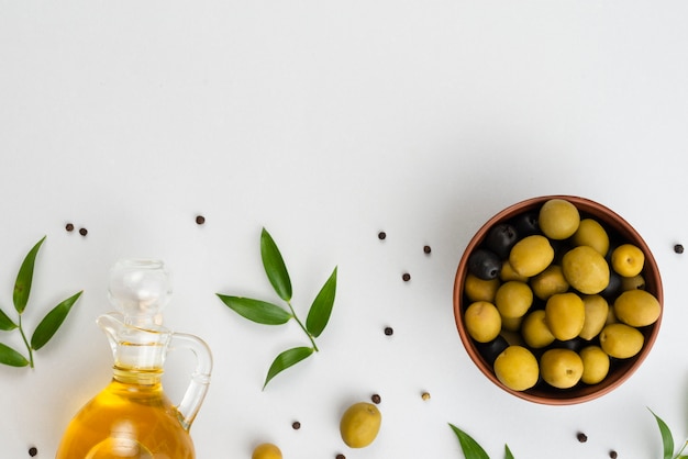 Flat lay olives in bowl and oil bottle