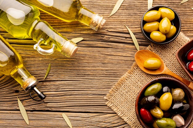 Flat lay olives in bowls oil bottles and leaves on textile material