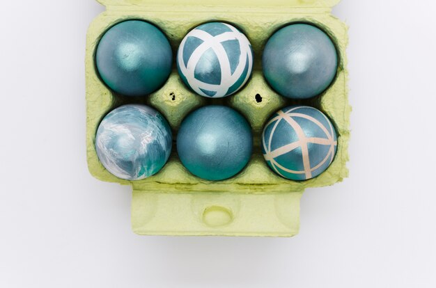 Free photo flat lay of painted easter eggs in carton