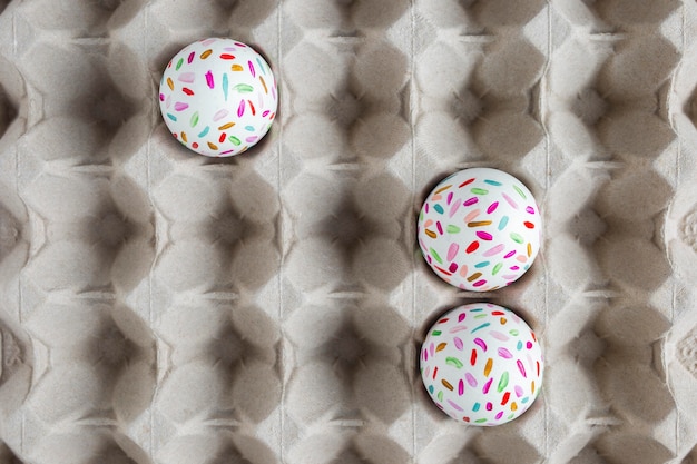 Free photo flat lay of painted easter eggs in carton