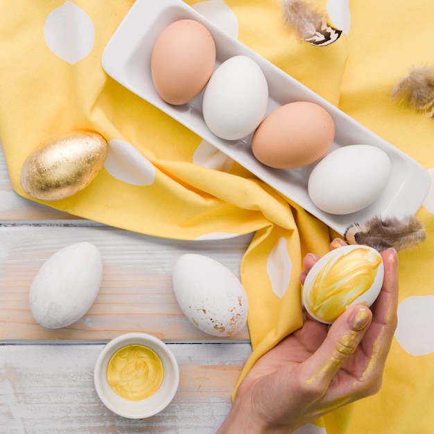 Flat lay of painted egg for easter held by hand