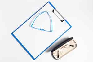 Free photo flat lay of pair of glasses in case and notepad