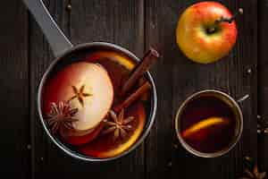 Free photo flat lay pan with mulled wine cup and apple