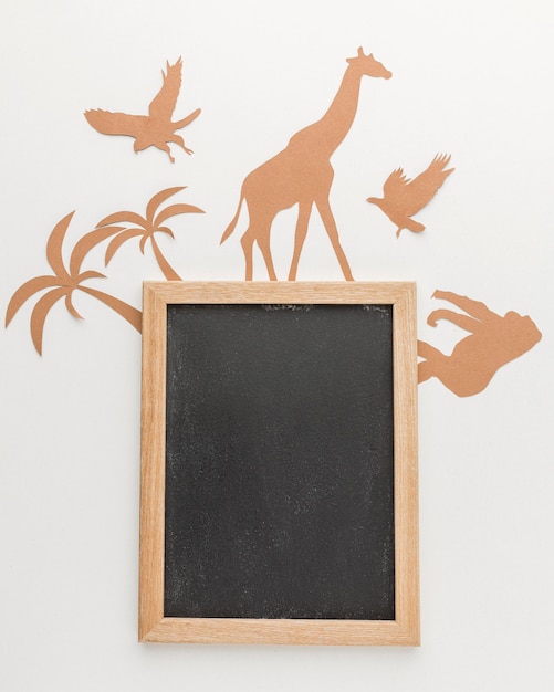 Flat lay of paper animals with blackboard for animal day