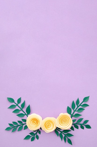 Flat lay paper flowers and leaves on purple background