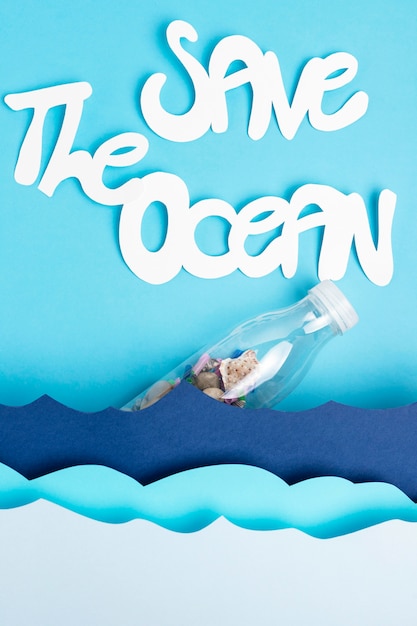 Free photo flat lay of paper ocean waves with plastic bottle and save the ocean