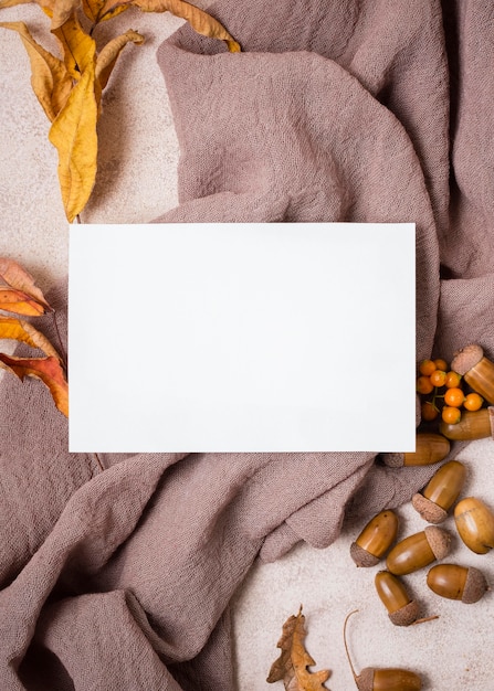 Flat lay of paper with autumn leaves and acorns