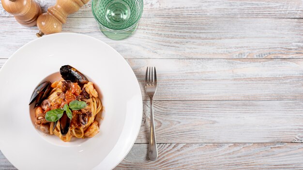 Flat lay of pasta and shells on wooden table