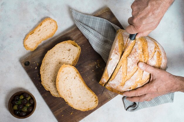 Flat lay person cutting slices of bread