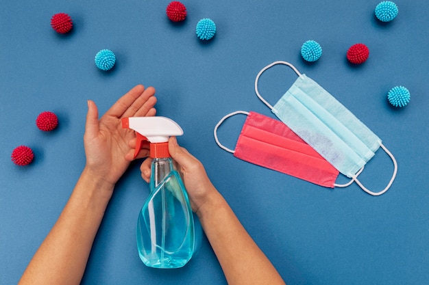 Free photo flat lay person disinfecting hands near medical masks