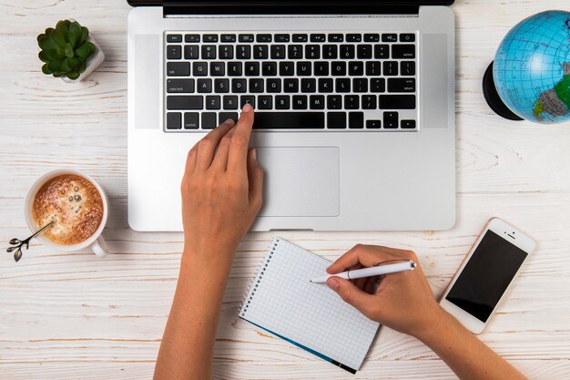 Flat lay person typing and writing